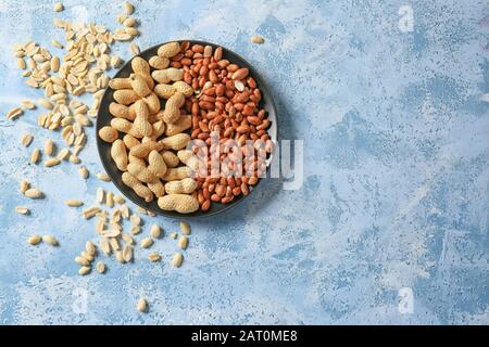 Plate with peanuts on color background Stock Photo