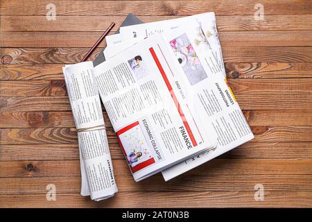 Many newspapers on wooden background Stock Photo