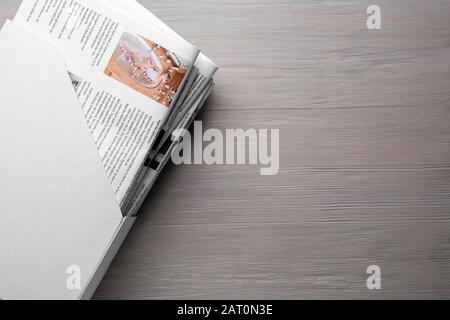 Holder with newspapers on wooden background Stock Photo