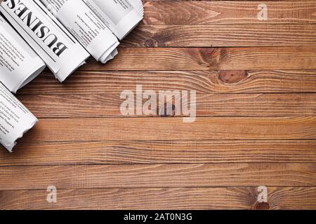 Many newspapers on wooden background Stock Photo