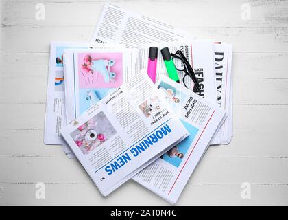 Newspapers and glasses on white wooden background Stock Photo