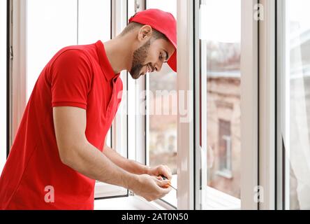 Young worker installing window in flat Stock Photo