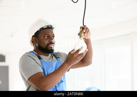 African-American Electrician Performing Wiring In Distribution Board ...