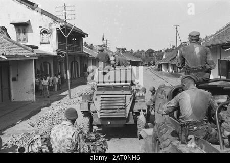 Sector Cheribon (1st Police Action 21-27 July 1947)  A column Dutch military vehicles preceded by an armored car driving through a street with on each side houses Date: July 1947 Location: Cheribon, Indonesia, Java, Dutch East Indies Stock Photo