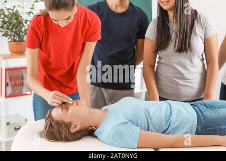 Instructor demonstrating CPR on woman at first aid training course Stock Photo