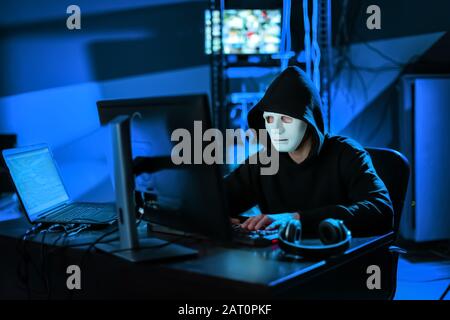 Professional hacker using computer in dark room Stock Photo