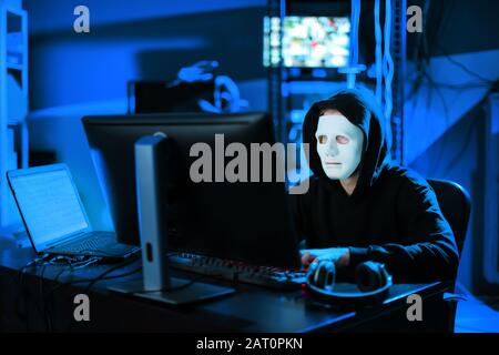 Professional hacker using computer in dark room Stock Photo