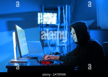 Professional hacker using computer in dark room Stock Photo