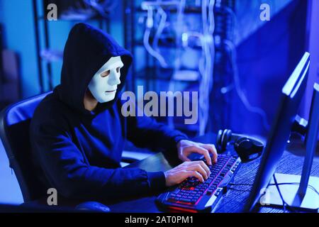 Professional hacker using computer in dark room Stock Photo