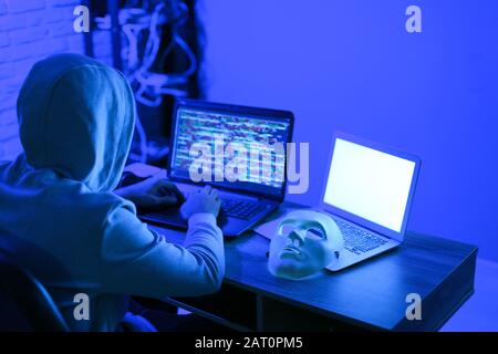 Professional hacker using laptop in dark room Stock Photo