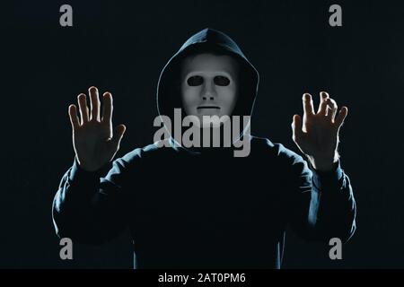 Professional hacker in mask on dark background Stock Photo