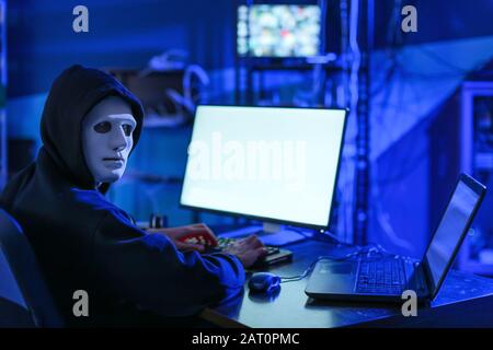 Professional hacker using computer in dark room Stock Photo