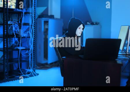 Professional hacker using computer in dark room Stock Photo