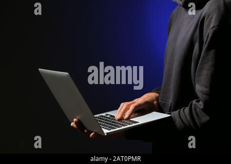 Professional hacker with laptop on dark background Stock Photo