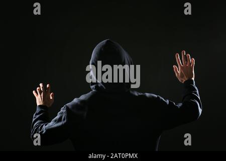 Professional hacker on dark background, back view Stock Photo