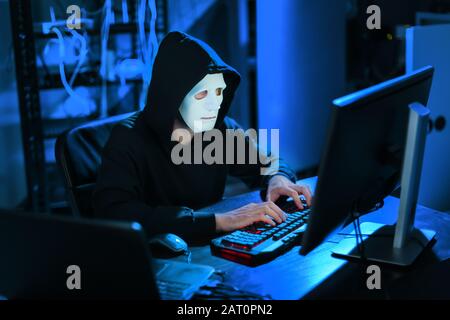 Professional hacker using computer in dark room Stock Photo