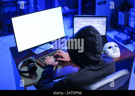 Professional hacker using computer in dark room Stock Photo