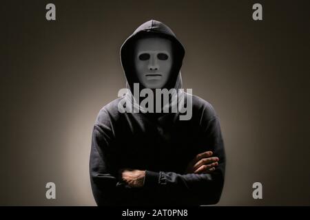 Professional hacker in mask on dark background Stock Photo