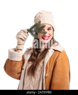 Happy young woman in winter clothes and with fir tree branch on white background Stock Photo
