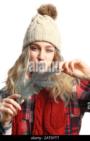 Happy young woman in winter clothes and with fir tree branch on white background Stock Photo