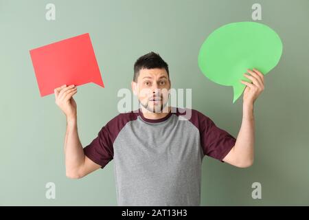 Man with blank speech bubbles on color background Stock Photo