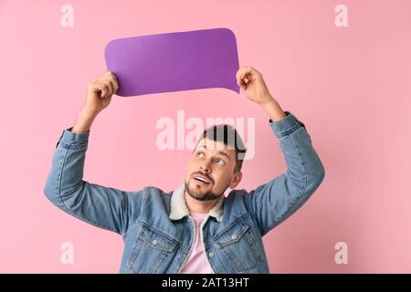 Man with blank speech bubble on color background Stock Photo