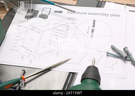 Furniture assembling plan with set of tools on table Stock Photo