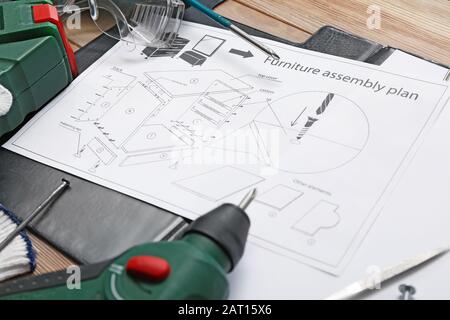 Furniture assembling plan with set of tools on table Stock Photo