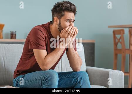 Portrait of worried young man at home Stock Photo