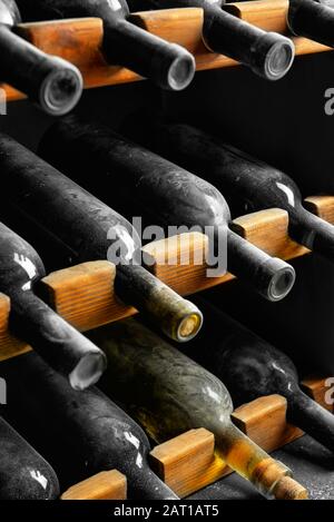 Wooden holder with bottles of wine in cellar Stock Photo
