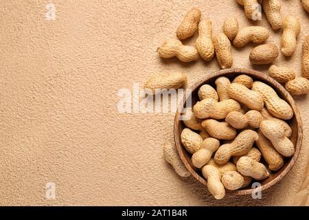 Plate with peanuts on color background Stock Photo