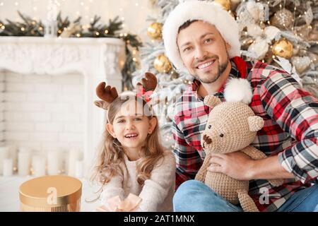 Happy father with little daughter in room decorated for Christmas Stock Photo