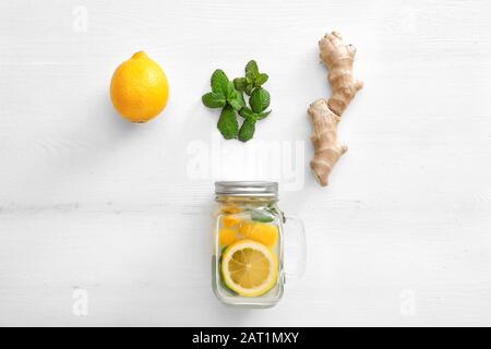 Composition with tasty ginger lemonade on white wooden background Stock Photo