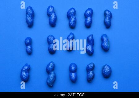 Blue painted peanuts on color background Stock Photo