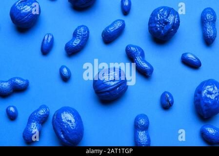 Blue painted nuts on color background Stock Photo