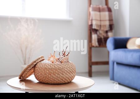 Box with sea shells on table in room Stock Photo