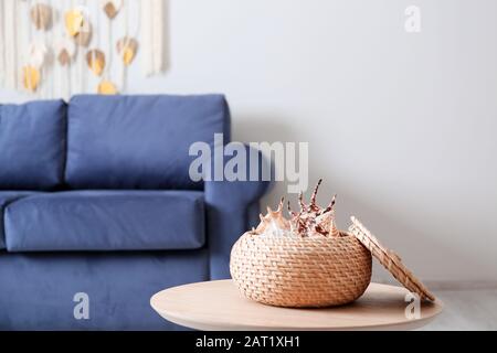 Box with sea shells on table in room Stock Photo