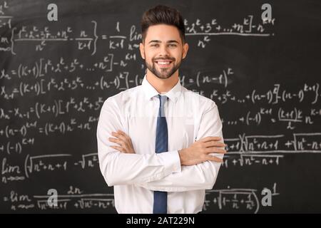 Male teacher near blackboard in classroom Stock Photo