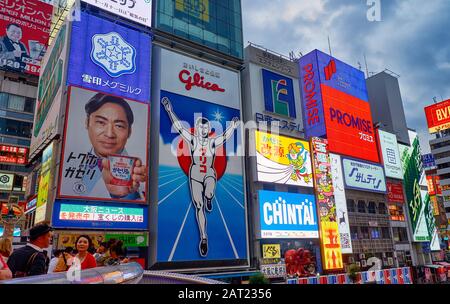OSAKA, JAPAN - OCTOBER 14, 2019:  The bright and flashy billboards along the Dotonbori canal with the symbol of the city, the Glico Running Man at nig Stock Photo