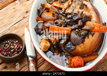 Roasted pork knuckle eisbein with vegetables on wooden background.Braised pork leg Stock Photo