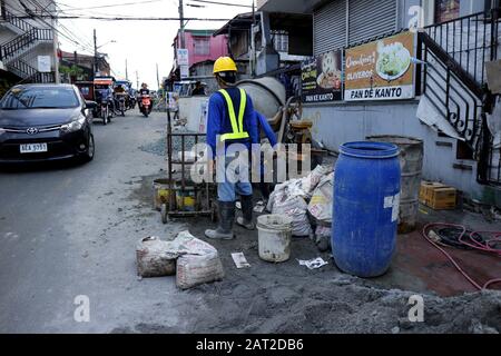 Antipolo City, Philippines - January 29, 2020: Vehicles pass along a street where a road construction project is on going. Stock Photo