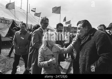 Demonstrative parade in Amsterdam by the Communist Party  Fré Meis gets a lick of an ice cream from a girl Date: March 27, 1971 Location: Amsterdam, Noord-Holland Keywords: demonstrations, ices, politicians, banners Personal name: Meis, Fré Institution name: CPN Stock Photo