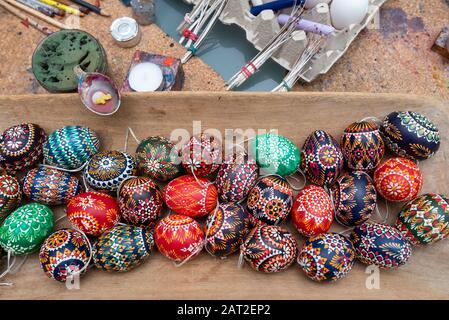 28 January 2020, Brandenburg, Lübbenau: In a bowl lie Sorbian eggs. Behind it, quills made of goose and pigeon feathers can be seen. They are dipped in wax, which is then dabbed onto the eggs. Thus, typical symbols such as the wolf tooth, the honeycomb or the sun wheel are created on the eggs. The Sorbs in the Lausitz are famous for the artistic decoration of Easter eggs. Photo: Stephan Schulz/dpa-Zentralbild/ZB Stock Photo