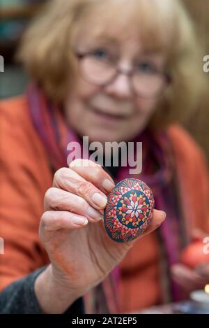 28 January 2020, Brandenburg, Lübbenau: Bärbel Lange holds a Sorbian Easter egg in her hand. Throughout the year she decorates white chicken eggs with the help of the wax batik technique or the bossier technique. The Sorbs in the Lausitz are famous for the artistic decoration of Easter eggs. Photo: Stephan Schulz/dpa-Zentralbild/ZB Stock Photo