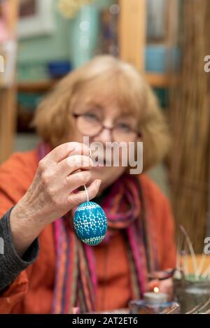 28 January 2020, Brandenburg, Lübbenau: Bärbel Lange holds a Sorbian Easter egg in her hand. Throughout the year she decorates white chicken eggs with the help of the wax batik technique or the bossier technique. The Sorbs in the Lausitz are famous for the artistic decoration of Easter eggs. Photo: Stephan Schulz/dpa-Zentralbild/ZB Stock Photo