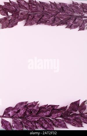 purple painted leaves on pink background . Creative layout border frame. Chic wedding invitation card mockup. Empty space, room for text. Stock Photo