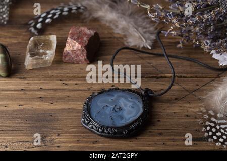 Divination with lavender, amulet, stones, feathers. Halloween background, occult and esoteric objects on witch wooden table, selective focus Stock Photo