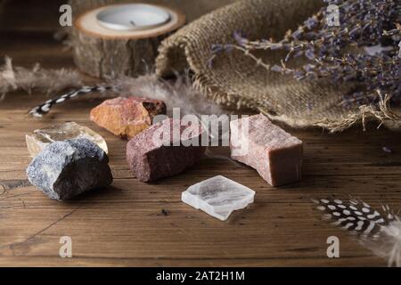 Divination with candle, lavender, stones. Halloween background, occult and esoteric objects on witch wooden table, selective focus Stock Photo