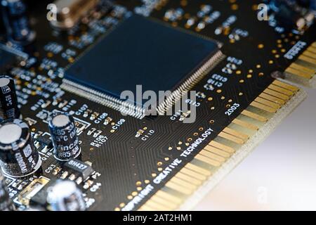 Electronic computer hardware technology. Photo of electric component in PC device, contain microchip, black capacitor and big resistor on printed circ Stock Photo