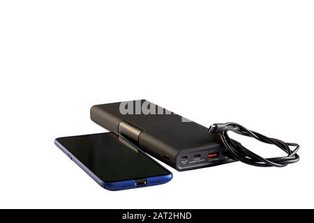 Black power bank with USB cable for smartphone on white background. Stock Photo